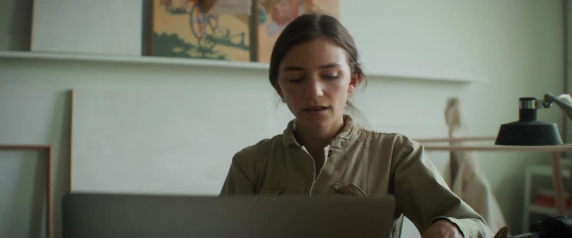 Woman sitting at the table with her laptop and writing