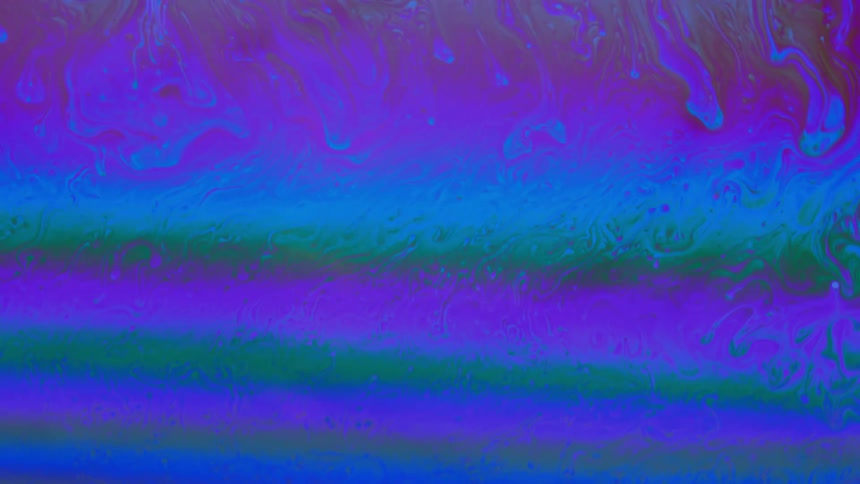 Oily layers in multicolored mixture swirl and flow