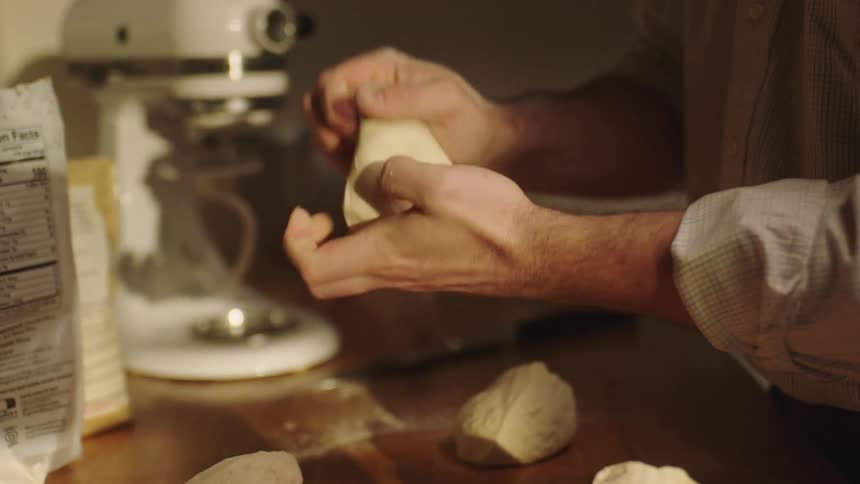 Closeup of a mans hands kneading dough with his hands