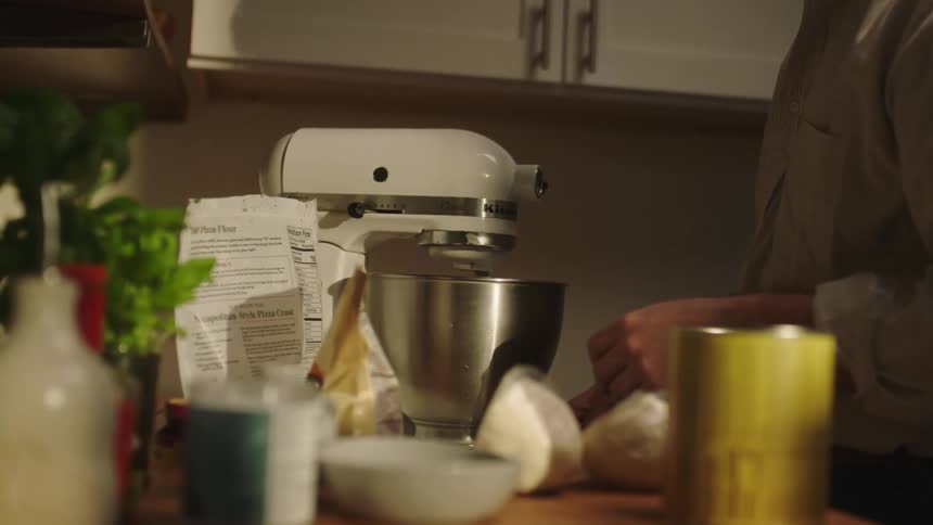 Man cooking and turning on a mixer