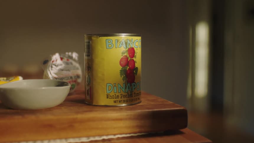 Wooden table with a canned sauce and a bowl