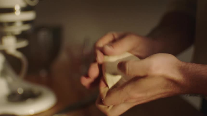 Closeup of a mans hands kneading dough