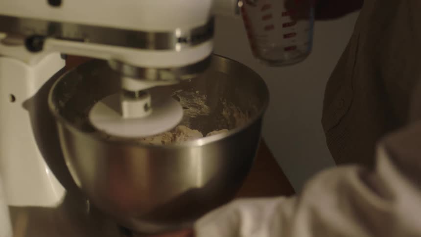 Closeup of a mixer in slow motion preparing dough