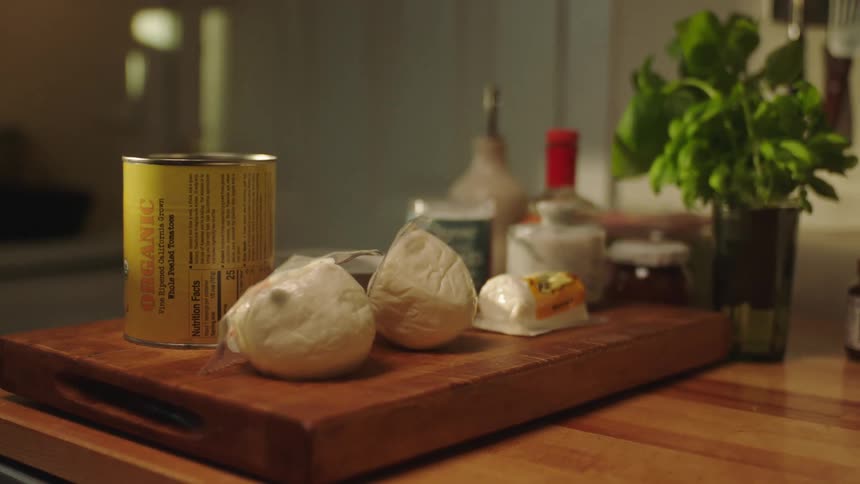 Wooden cutting board with ingredients on top of a table