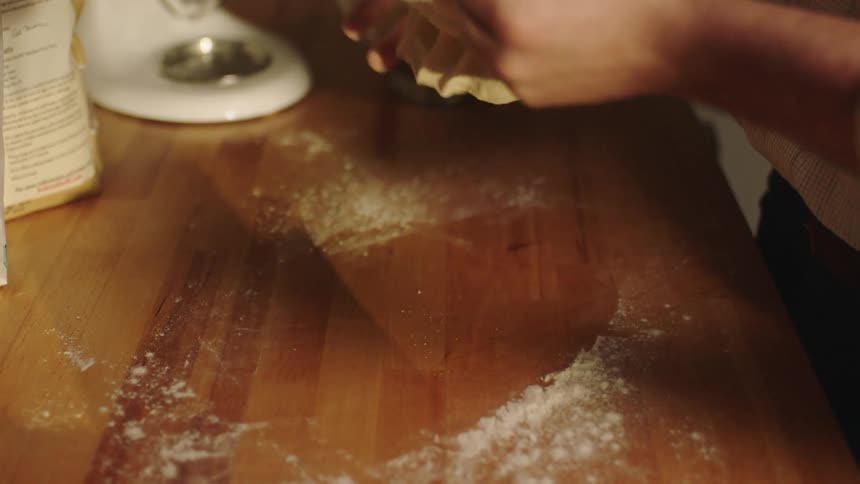 Man kneading dough in the kitchen at home