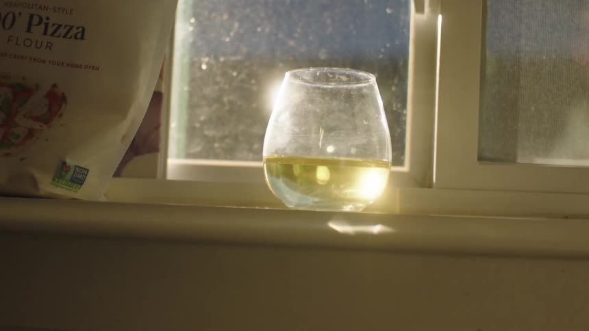 Sunlight shines on a glass next to the window