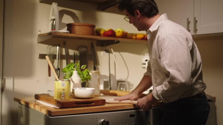 A man passing flour on a wooden board
