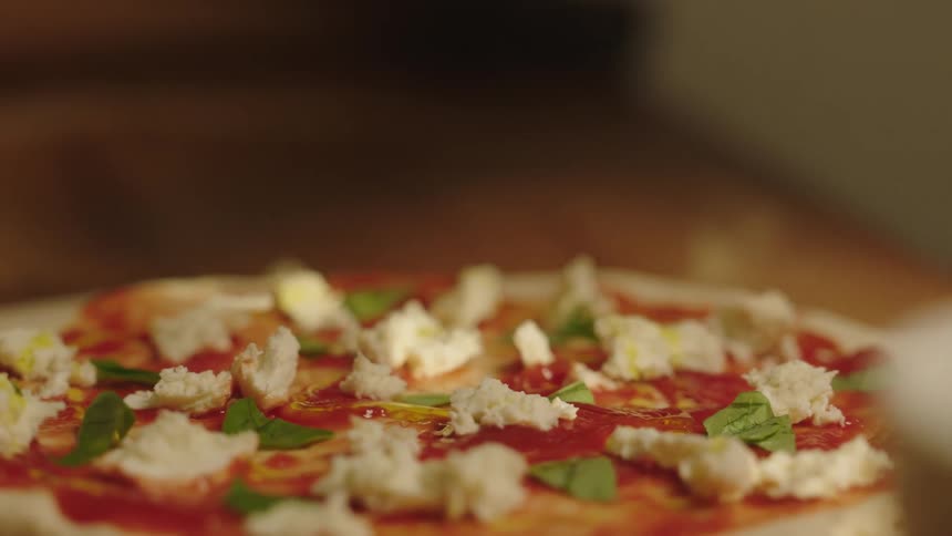 Oil pouring over a freshly made mozzarella pizza
