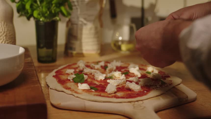 A person is making pizza at home
