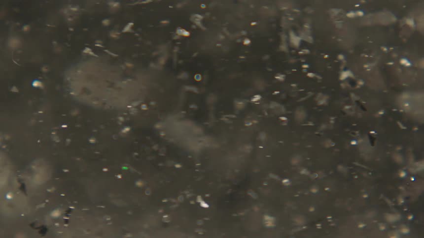 Water fluid with confetti swirling in slow motion