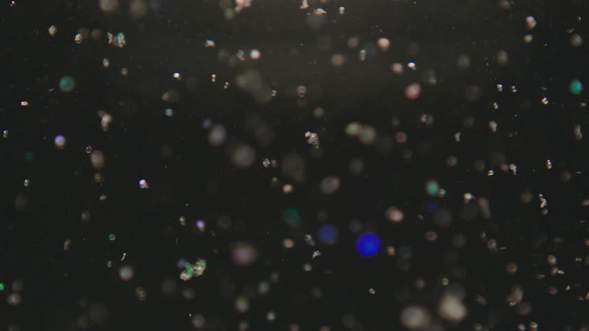 Shiny shimmering particles floating in liquid