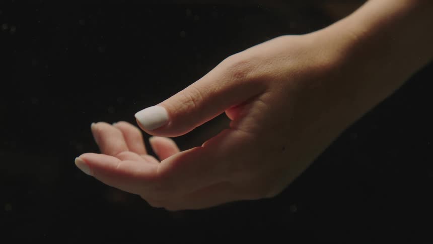Closeup of a womans hand with white nails