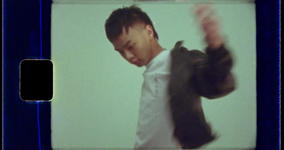 Teenager wearing a black leather jacket and a white t shirt poses for the camera