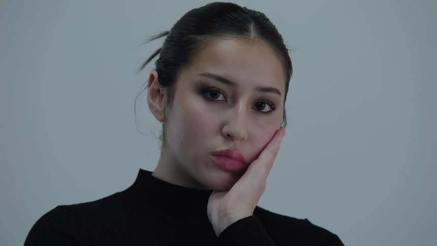 Woman with one hand on her face posing
