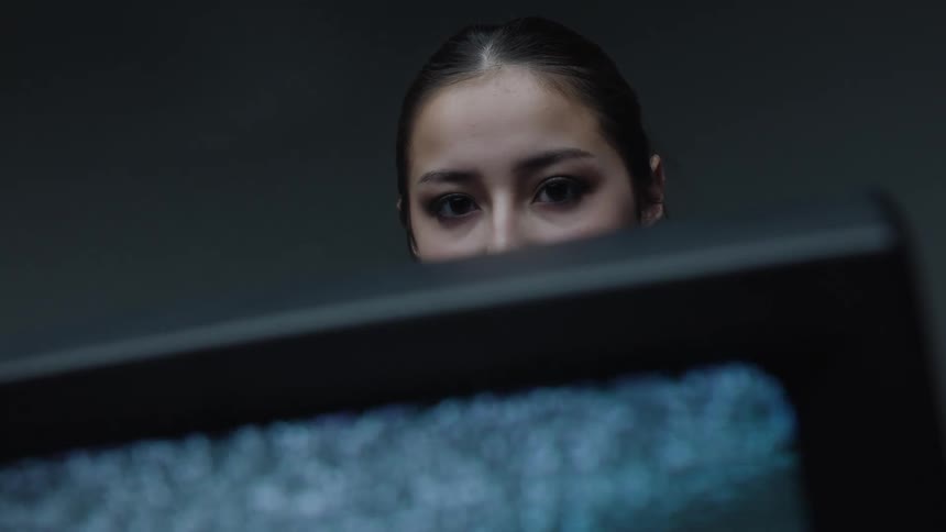 A woman standing behind an old television screen