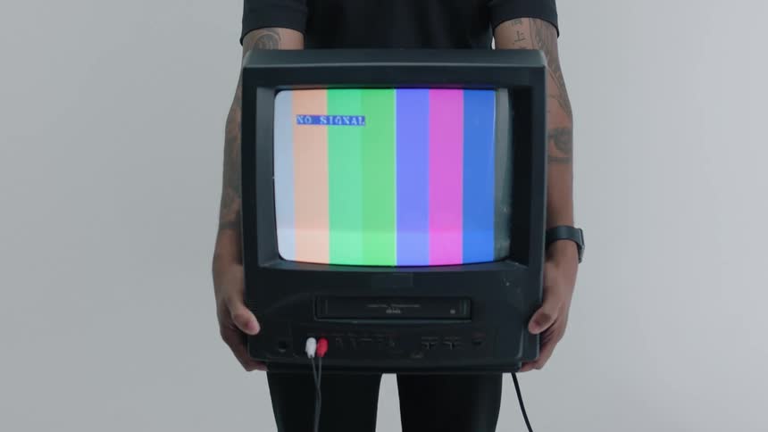 Man holding a vintage television with retro images