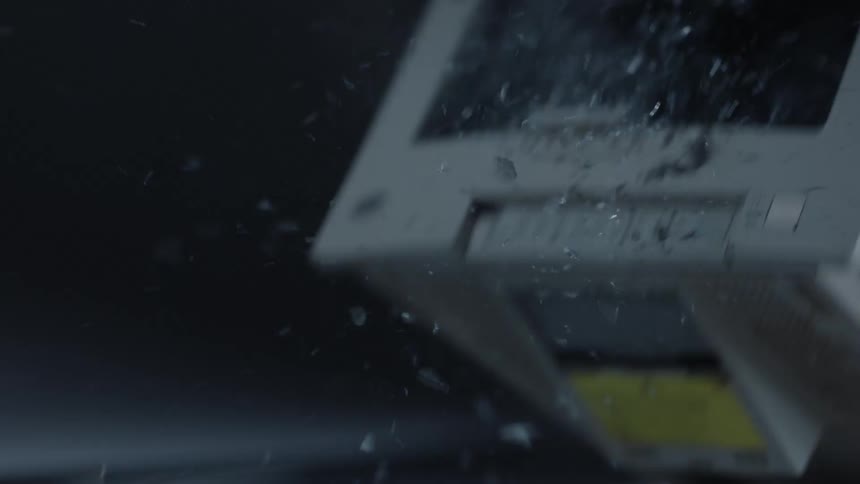Hammer smashing the screen of a vintage monitor