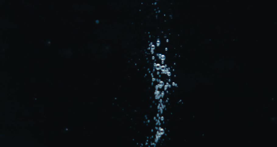Extreme closeup of a spiral underwater with bubbles in slow motion