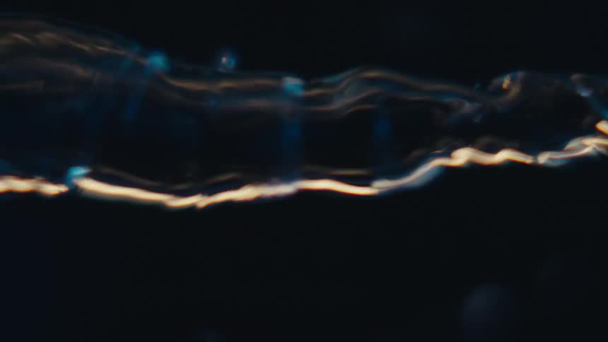 A tornado of water with light shining in the darkness