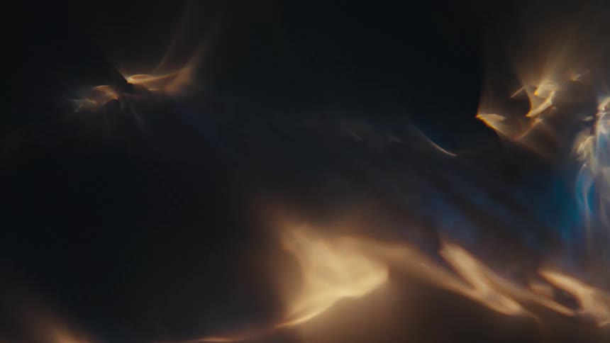 Close up of horizontal liquid vortex highlighted by golden light