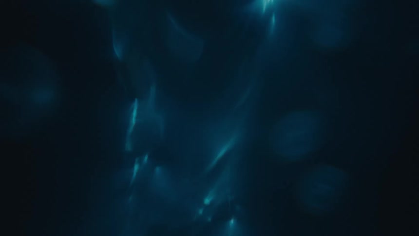 Water droplet inside a liquid starting to spiral in an abstract manner