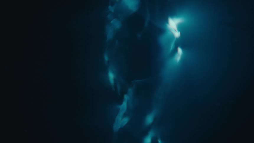 A blue and reflective fluid is falling