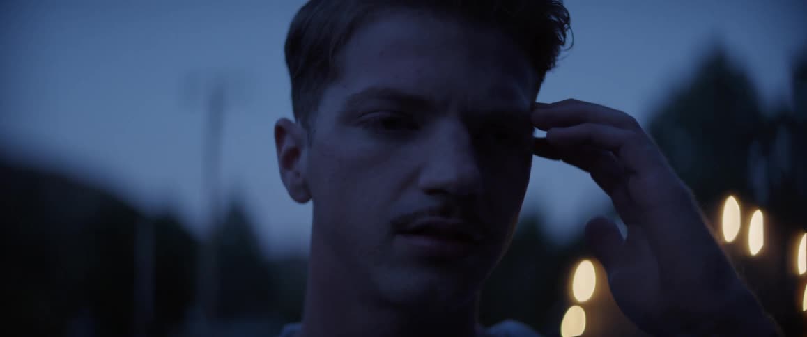 A man looks back and rubs his face