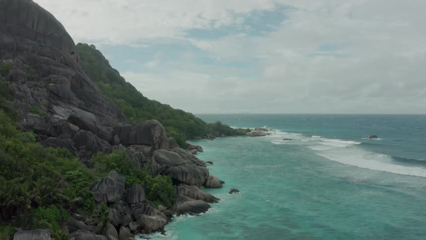 Aerial of the coast of a deserted beach with mountains
