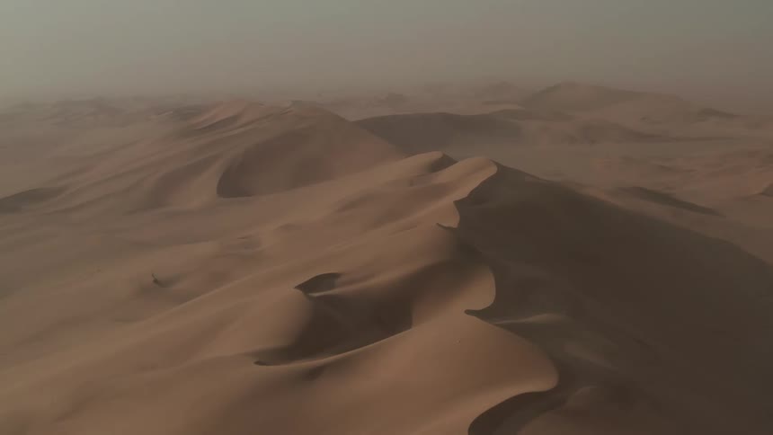 Drifted sand of the desert dunes under a hazy sky
