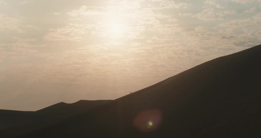 Panorama of mountain dunes with the sun breaking through the clouds