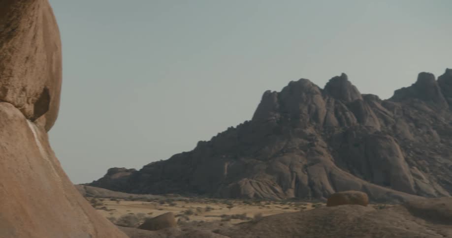 Woman walking with her back to the camera amidst nature under the valleys