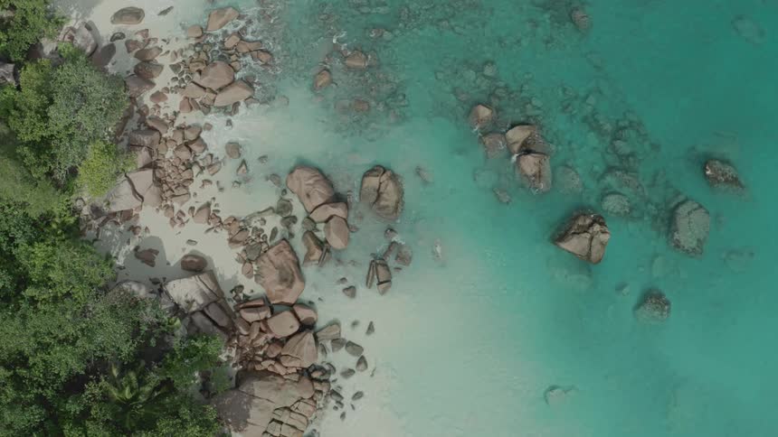 Aerial of rocks and sea water in a coastal area at midday