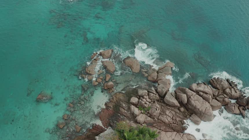 Aerial view of a small island under crystal clear blue sea