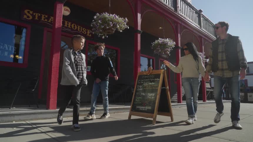 Family walking on the sidewalk with two children in the daylight