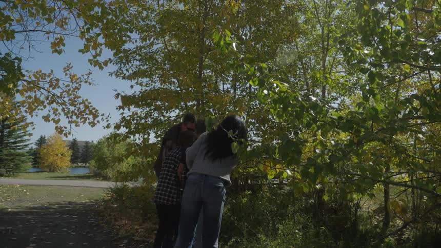 Two people in the park looking into the bushes
