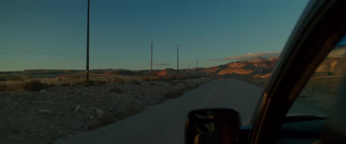 Car driving on a road in the desert at morning