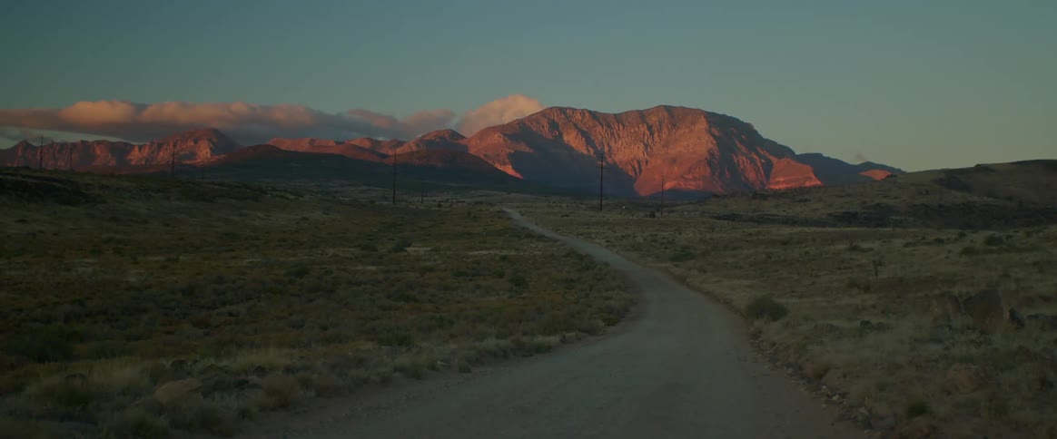 Landscape of a street amid a setting with a mountain range on the horizon in the morning