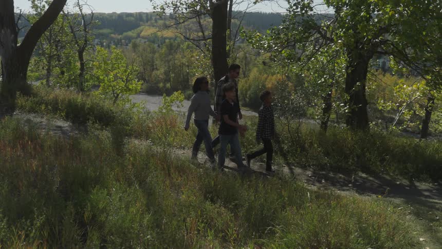 Family walks along nature path across river from residential neighborhood