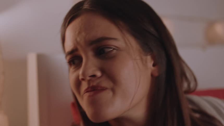 A woman looking sad is reaching for something