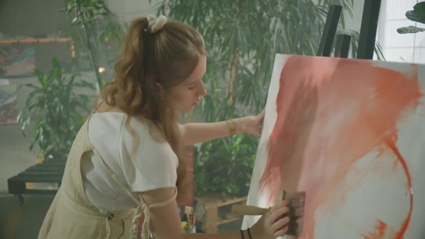 A female artist painting with a brush on a canvas