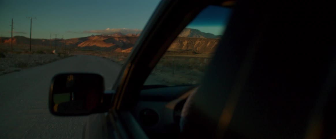 Vehicle in the middle of the street with a mountain range on the horizon in the morning