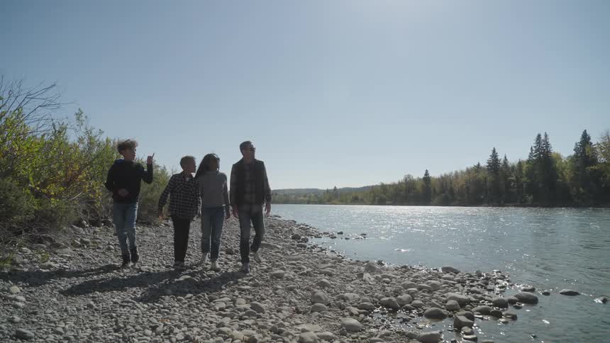 Family enjoys a walk along the coastline of a river