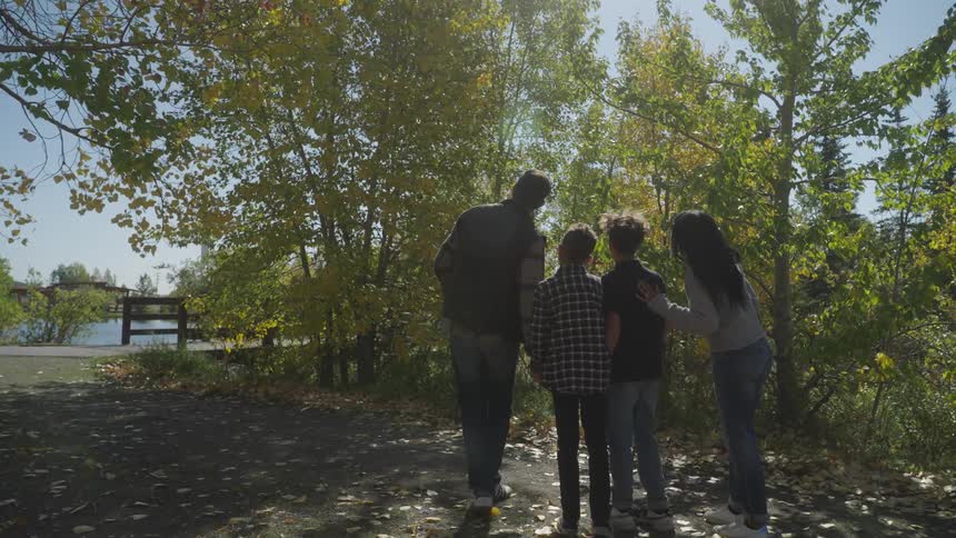 Family of four look at nature in a park