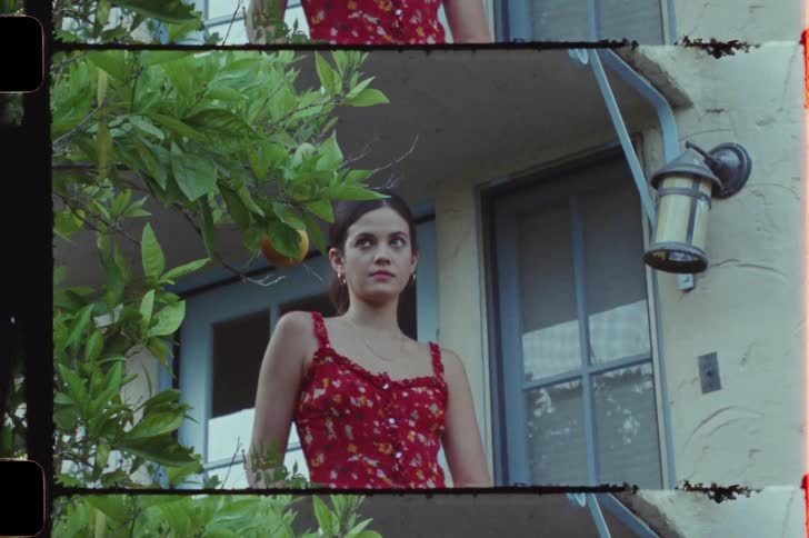 Man and woman talking on the balcony at midday with the man walking down the stairs