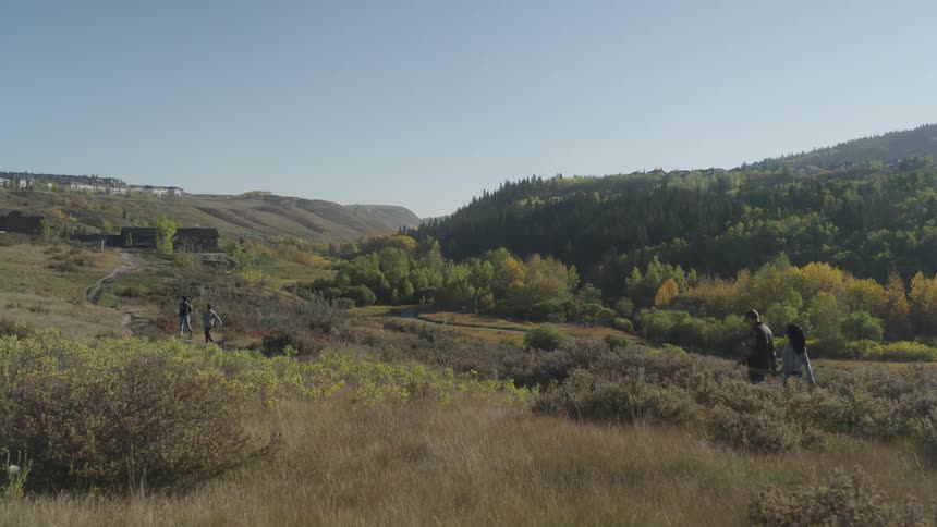 A family walks through a field in a rural area during the day
