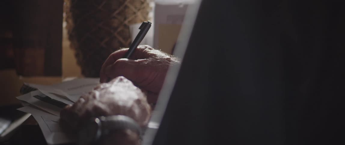 Hand of an elderly person writing on paper