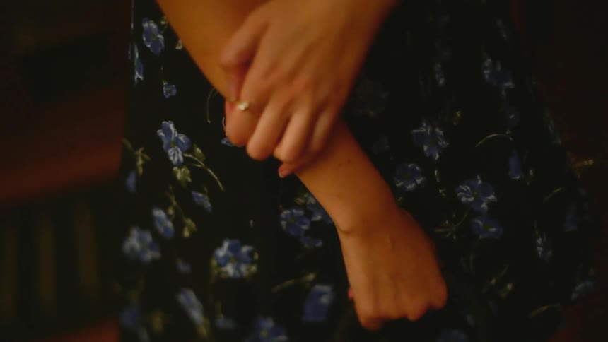 Woman in a dress and small silver heels inside an indoor space