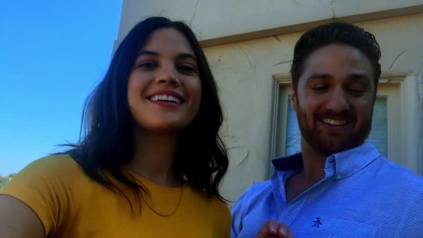 Woman and man take selfie video outdoors during the day