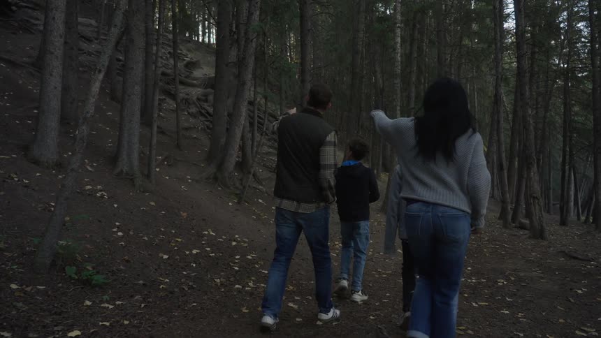 A family walking through a forest during autumn