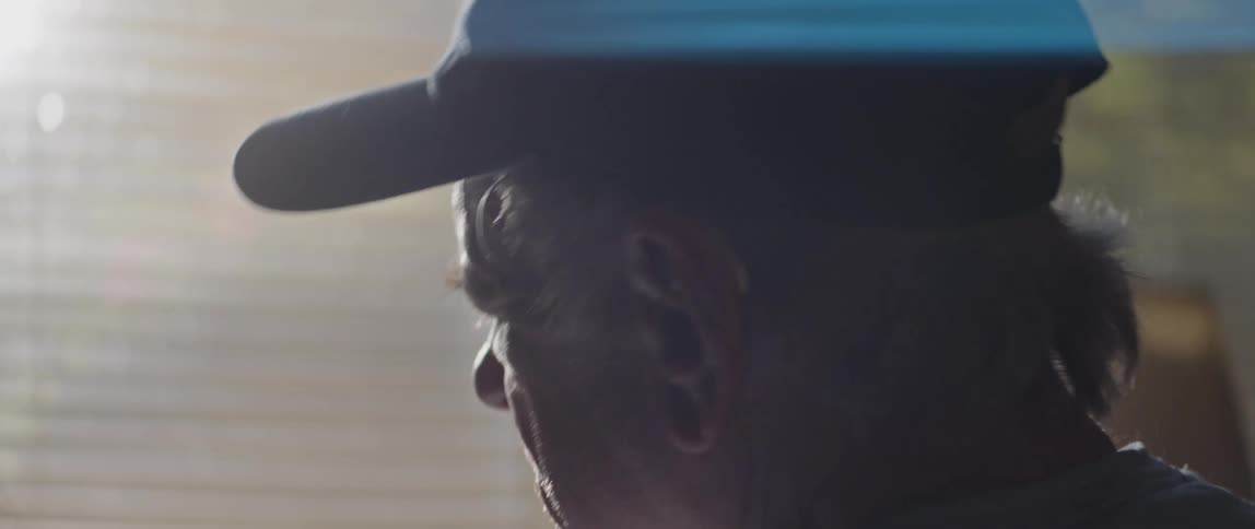 A sad man looking at his hat